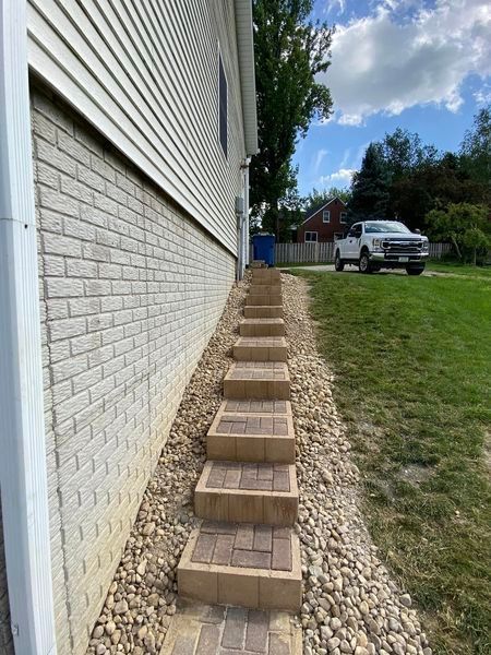 There are stairs leading up to the side of a house.