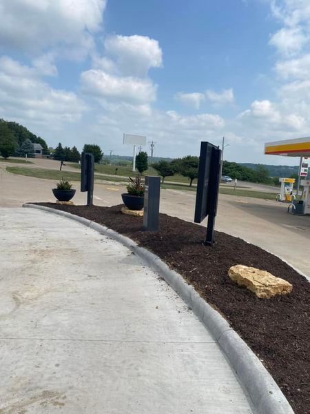 A gas station with a lot of planters and signs