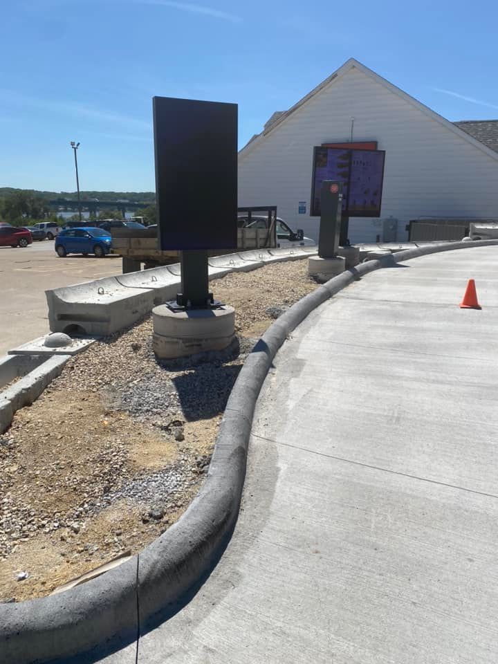 A concrete curb is being installed in front of a building.