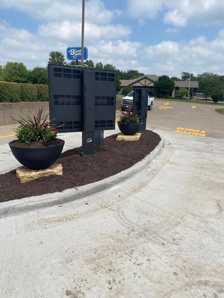 A parking lot with planters and a sign that says drive thru