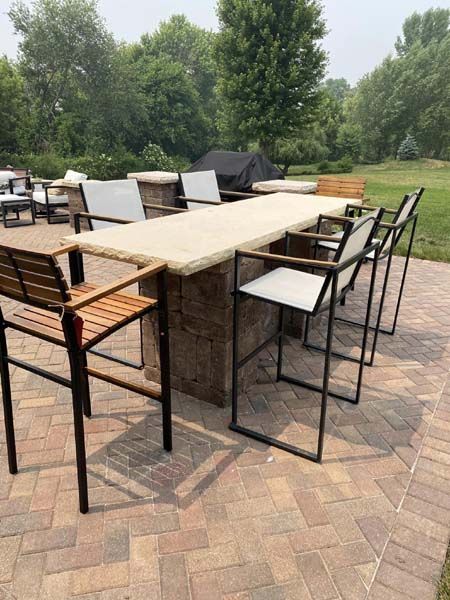 A table and chairs are sitting on a brick patio.