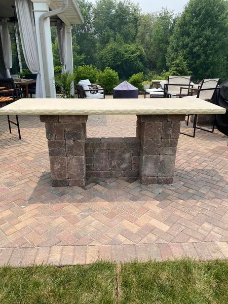 A large table is sitting on top of a brick patio.