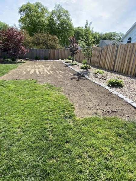A lush green lawn with a wooden fence in the background.