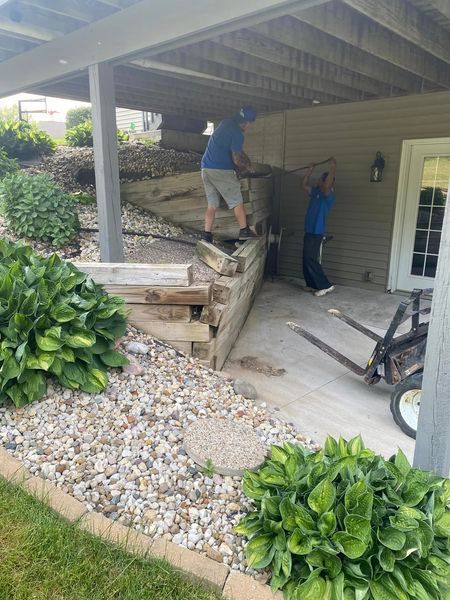 A couple of men are standing under a porch.