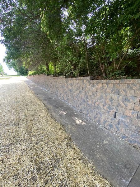 There is a brick wall along the side of the road.