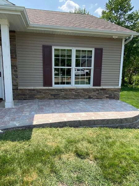 A house with a patio in front of it and a large window.
