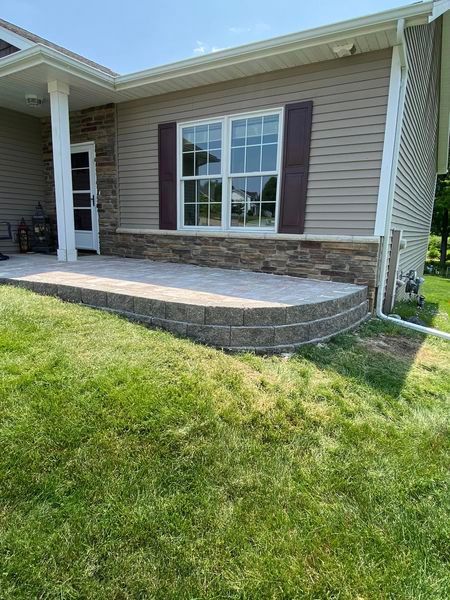 A house with a patio in front of it and a large window.