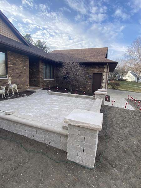 A brick house with a patio in front of it.
