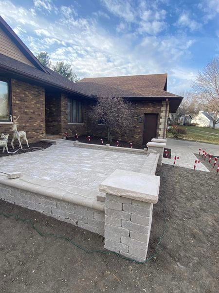 A brick house with a patio in front of it.