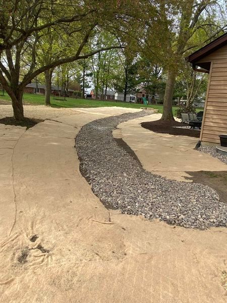 A dirt path leading to a house in a park.