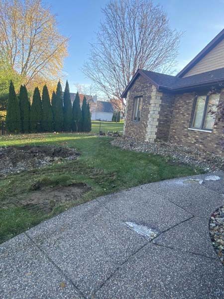 A brick house with a concrete driveway in front of it.