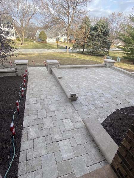 A patio with a hose attached to it is being built in a backyard.