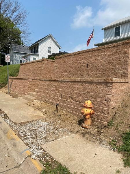 A brick wall with a fire hydrant in front of it