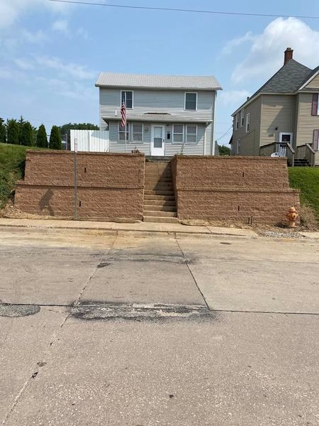 A brick wall with stairs leading up to a house
