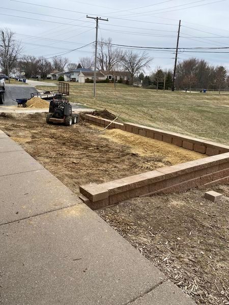 A bulldozer is moving dirt in a yard next to a sidewalk.
