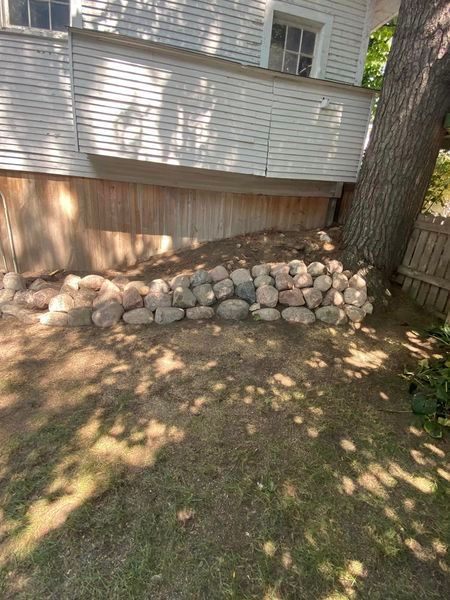 A pile of rocks is sitting in front of a house.