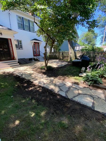 A white house with a stone walkway leading to it.