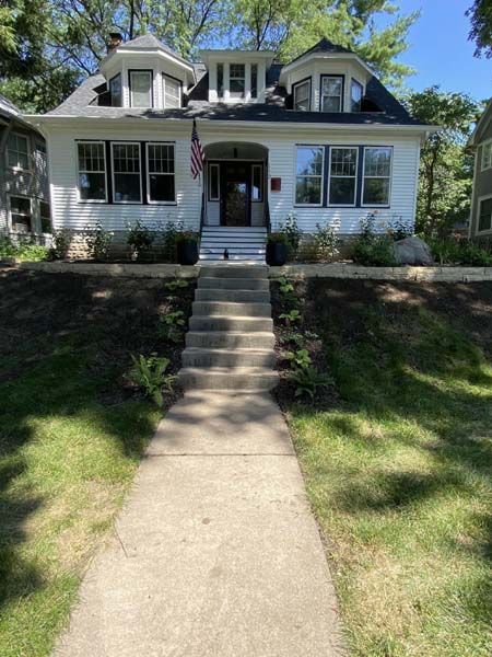 A white house with stairs leading up to the front door.