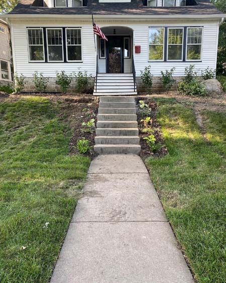 A white house with stairs leading up to the front door.