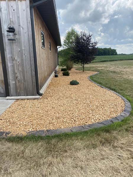 A house with a walkway surrounded by mulch and gravel.