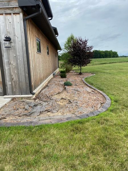 A house with a walkway leading to it and a lawn in front of it.