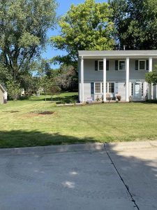 A large white house with a large lawn in front of it.