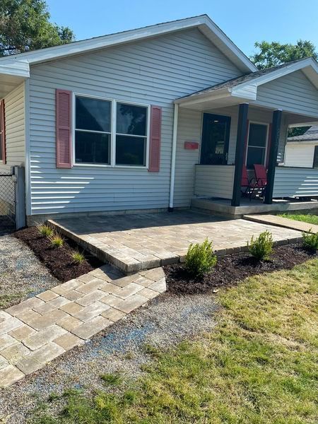 A white house with pink shutters and a walkway in front of it