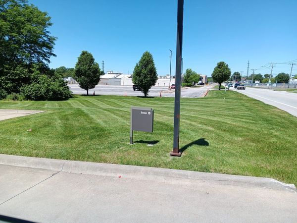 A lush green field with a sign in the middle
