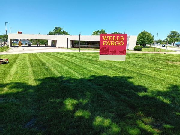 A wells fargo sign is in the middle of a lush green field