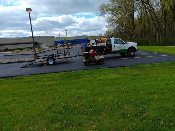 A truck with a trailer attached to it is parked in a parking lot.