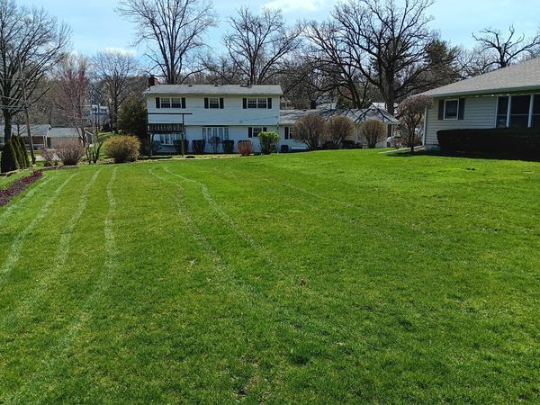 A large lush green lawn in front of a house.