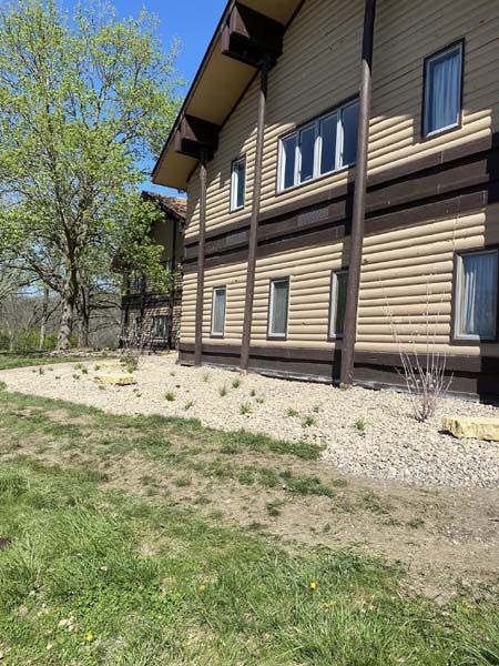 A large house with a lot of windows and a lot of grass in front of it.