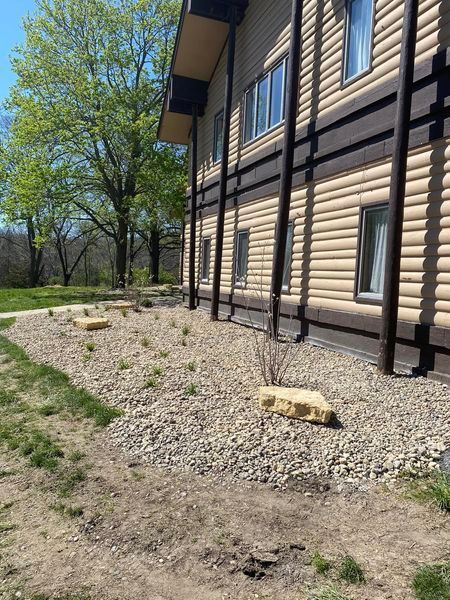A large building with a lot of windows and a lot of rocks in front of it.