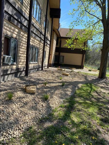 A large building with a lot of windows and a lot of rocks in front of it.