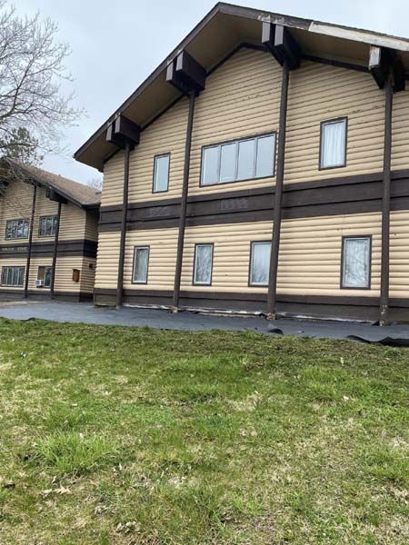 A large building with a lot of windows and a lot of grass in front of it