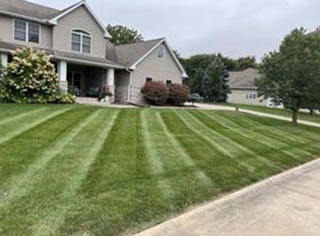 A large house with a lush green lawn in front of it.