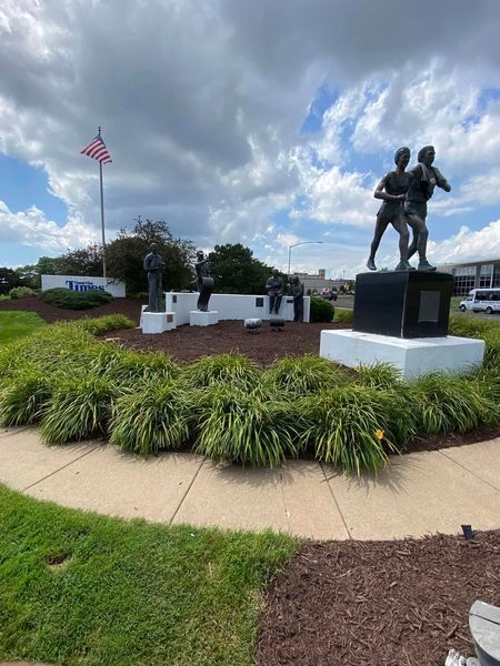 A statue of two men standing next to each other in a park.