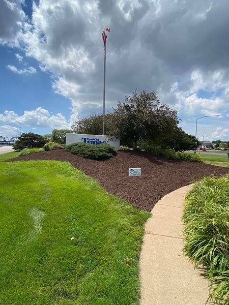 A walkway leading to a building with a flag pole in the background.