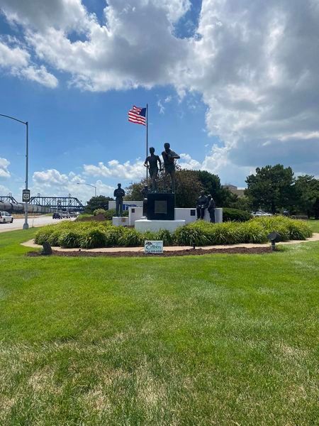 A statue in a circle with a flag in the background