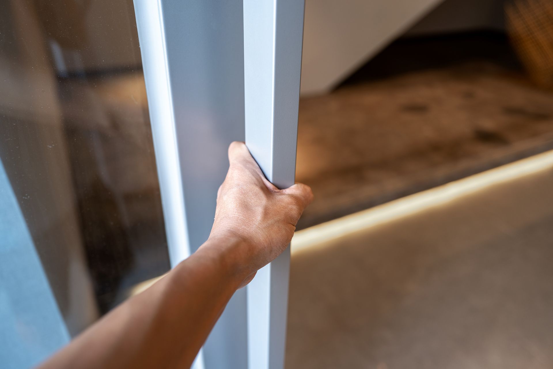 Una persona sta aprendo una porta con la mano.