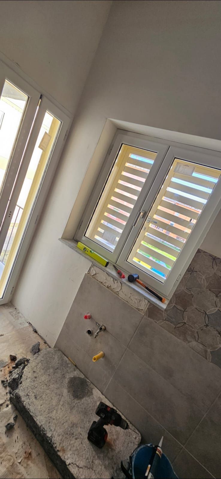 Una stanza con una finestra e una porta scorrevole in vetro.