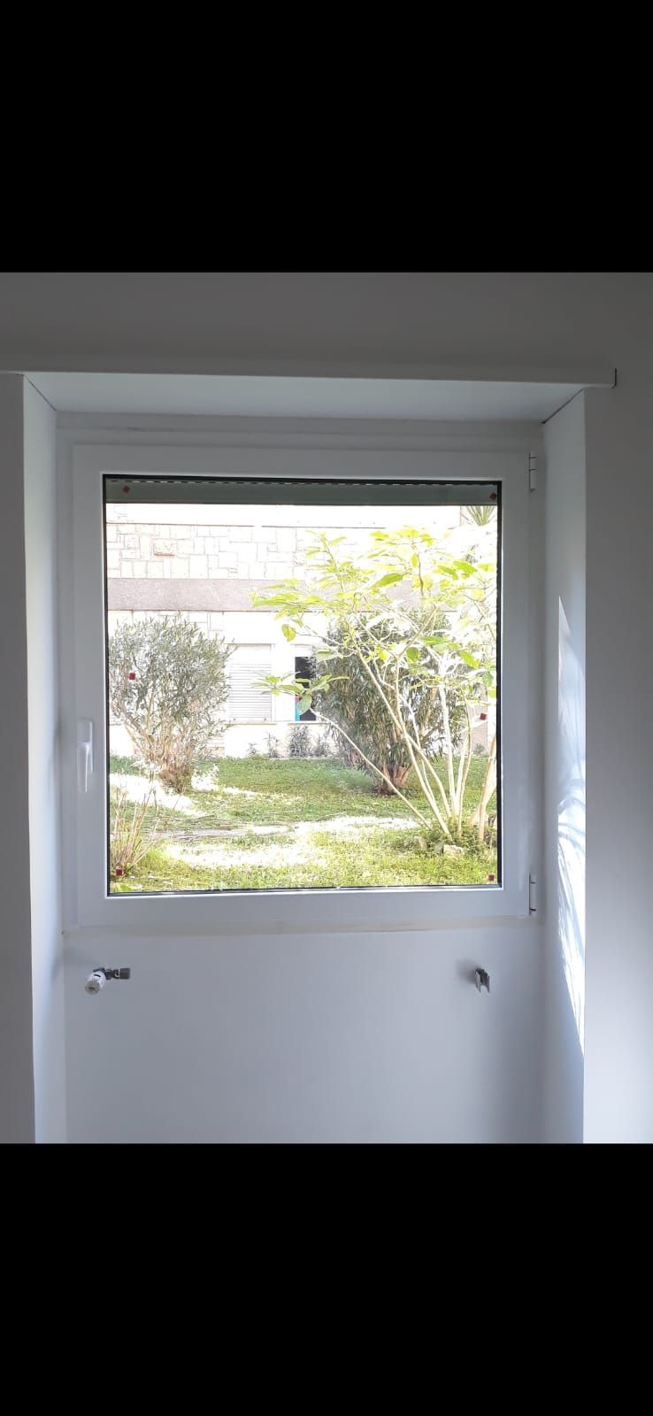 Una finestra in una stanza con vista sul giardino.