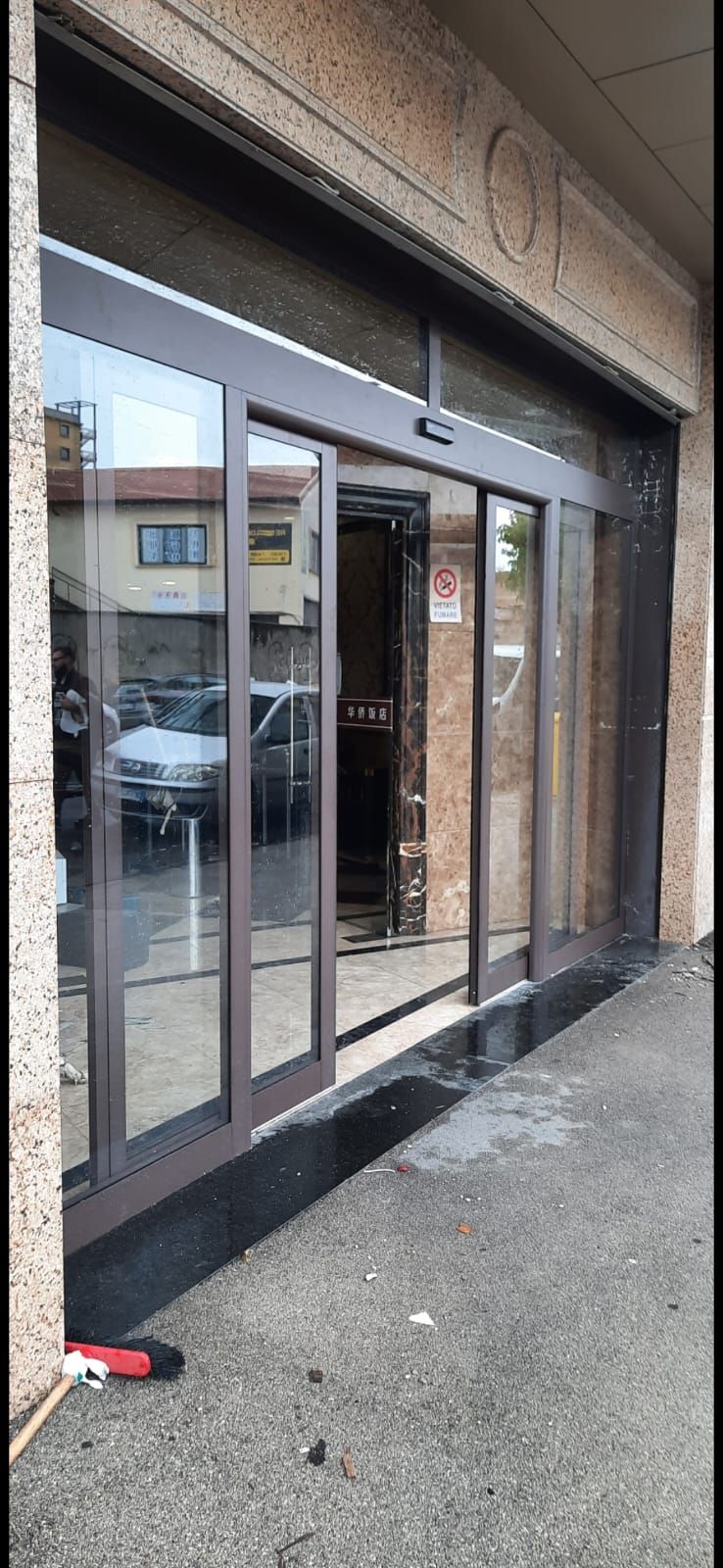 Una grande porta scorrevole in vetro è aperta su un edificio.