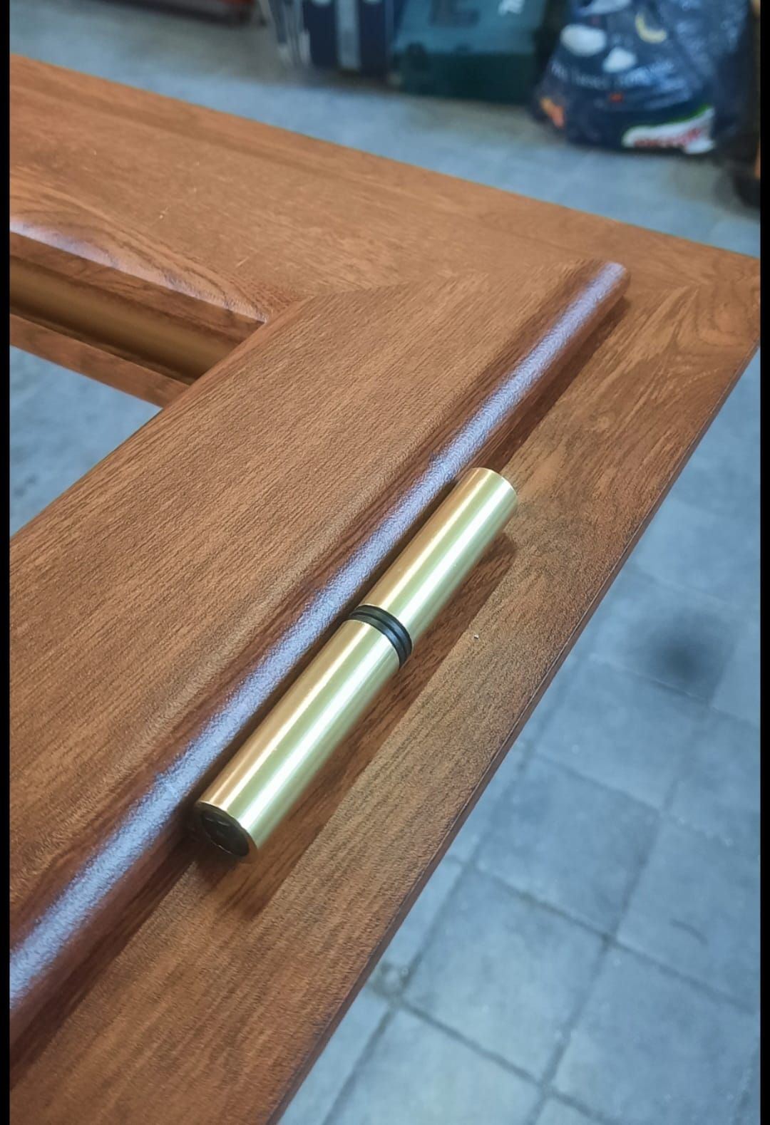 Un primo piano di una porta di legno con una cerniera in ottone