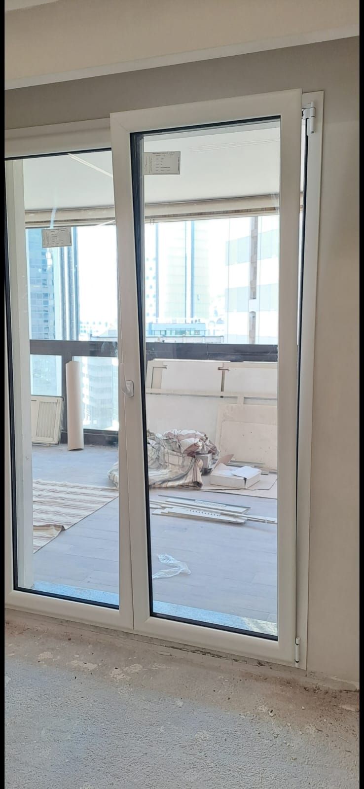 Una stanza vuota con una porta scorrevole in vetro che conduce a un balcone.