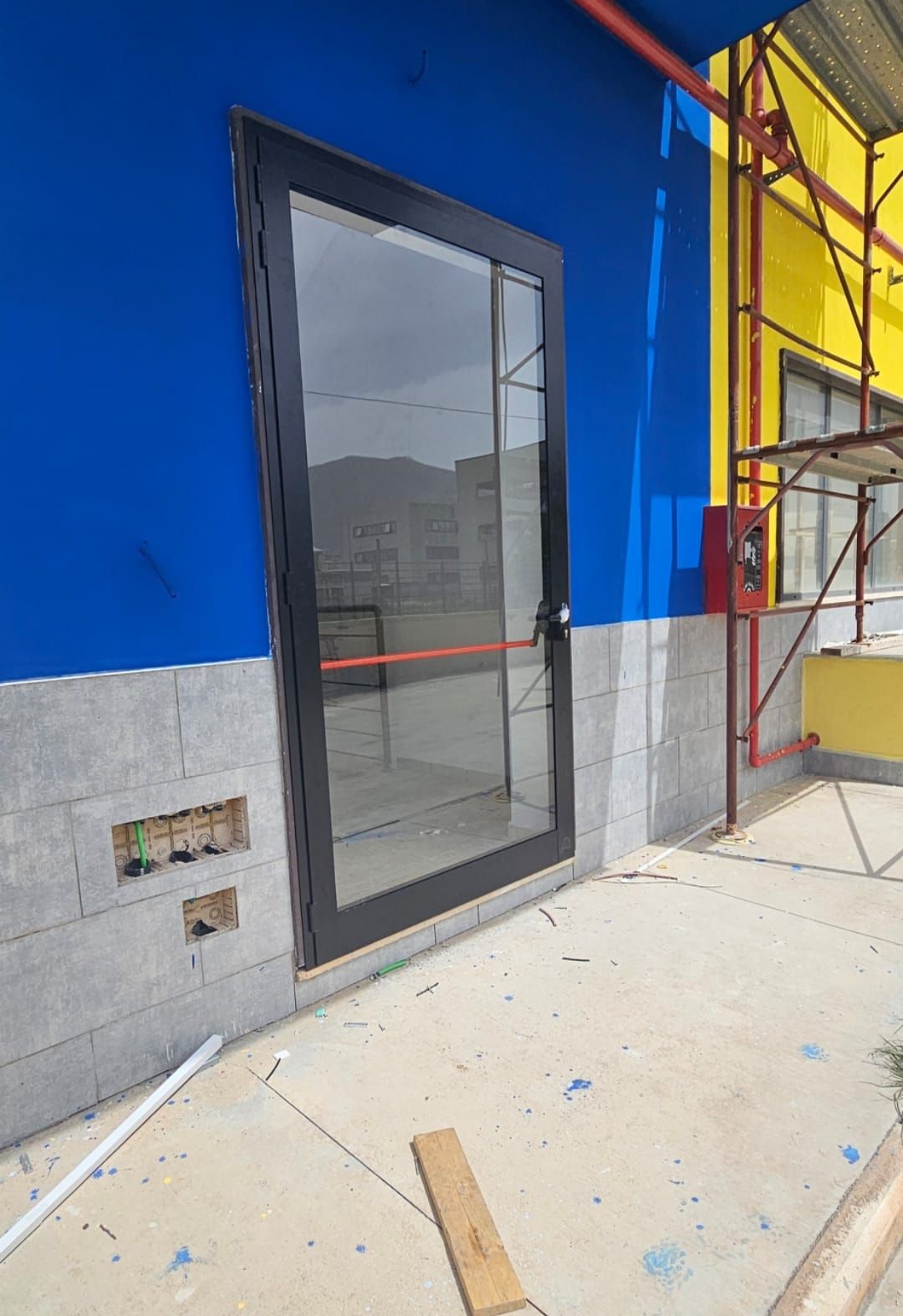 Un edificio blu e giallo con una grande porta a vetri