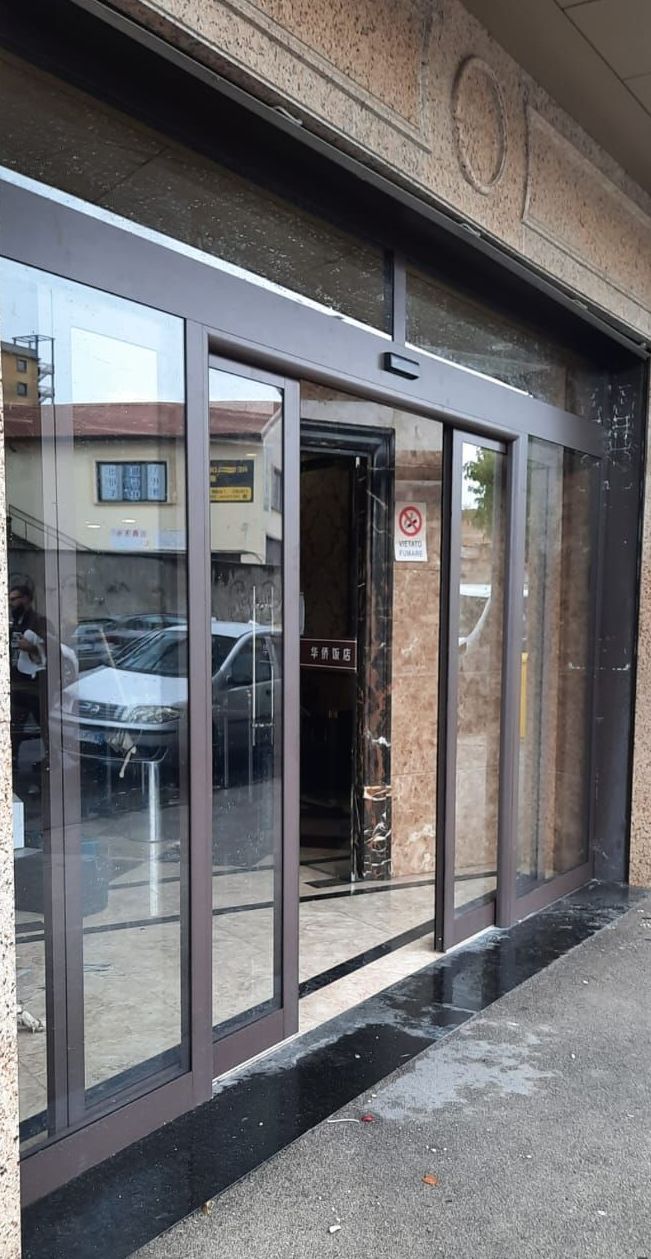 Una grande porta scorrevole in vetro è aperta su un edificio.