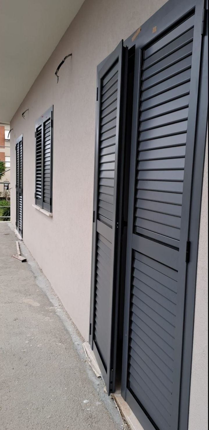 Un edificio con molte finestre e persiane.