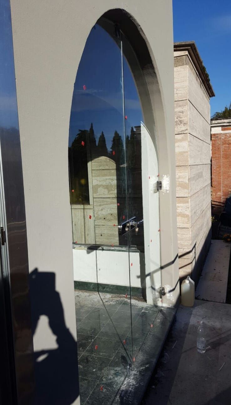 L'ombra di una persona è proiettata su una porta di vetro rotta