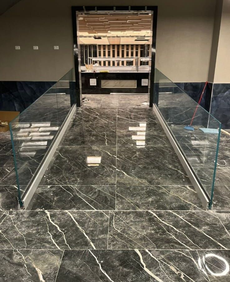 Un pavimento in marmo con ringhiera e scale in vetro